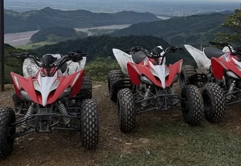 Cuatro cuatrimotos rojas en el mirador, con Villavicencio y el piedemonte llanero al fondo